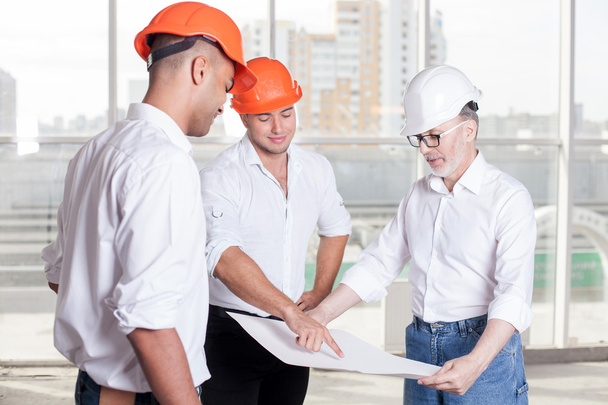 Successful skilled builders are discussing a new building - Foto, imagen