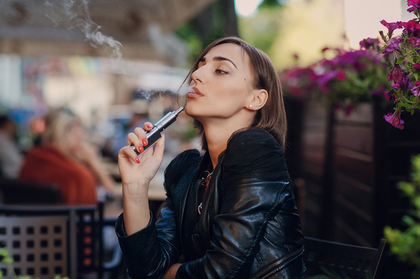 beautiful glamorous brunette smoke electronic cigarette - Foto, afbeelding