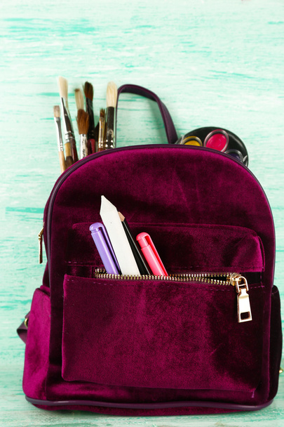 Backpack with school supplies on wooden background - Fotó, kép
