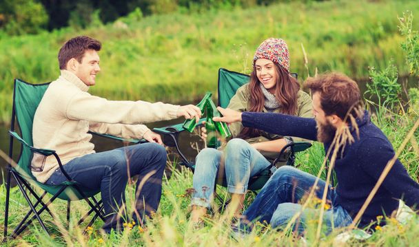 group of smiling tourists drinking beer in camping - Fotografia, imagem