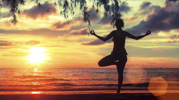 Silhouette di giovane donna che pratica yoga
 - Foto, immagini