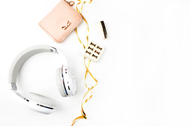 Music headphones, gold ribbon and blush handbag on white background top view. Mock-up. Feminine scene. header site or hero site. Blog image. Flat lay - Photo, Image
