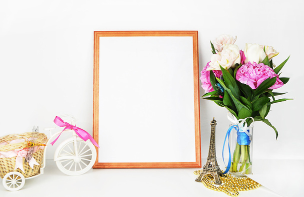 Frame mockup, pioenrozen in vaas en goud accessoires, witte backgorund - Foto, afbeelding