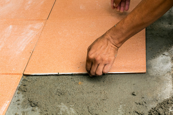 Mies Rakennustyöntekijä laatoittaa kotona, laatta lattia liima r
 - Valokuva, kuva