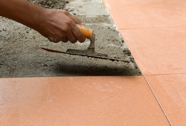 a plasterer is tiling at home, tile floor adhesive renovation - Photo, Image