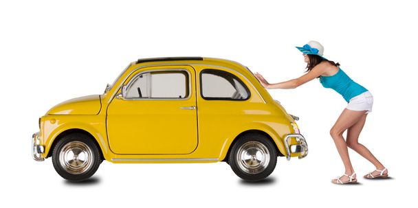 Young woman pulling car on white backround - Zdjęcie, obraz