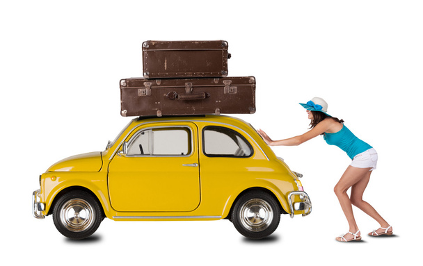 Young woman pulling car with suitcases - 写真・画像