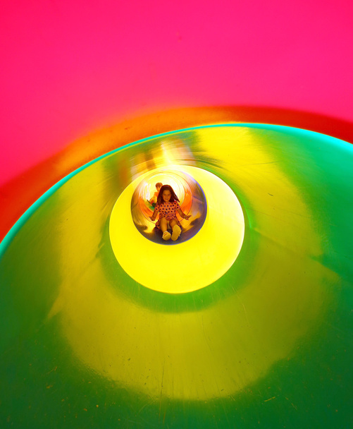 κοριτσάκι στην παιδική χαρά που έρχεται κάτω σε μία μεγάλη σήραγγα διαφάνεια - Φωτογραφία, εικόνα