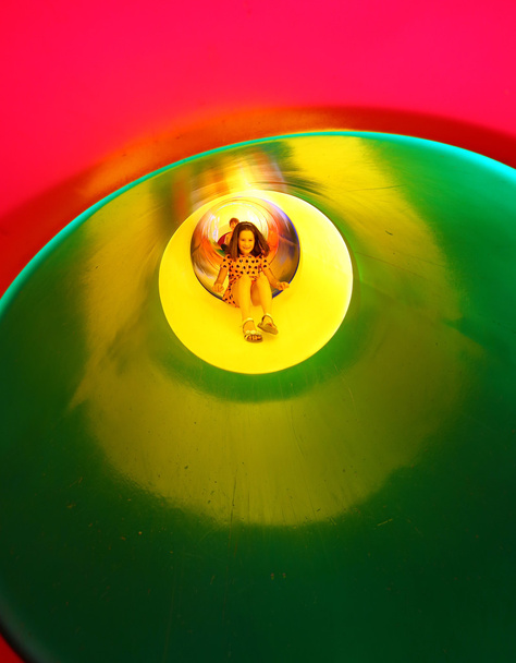bambina nel parco giochi in un colorato scivolo tunnel
 - Foto, immagini