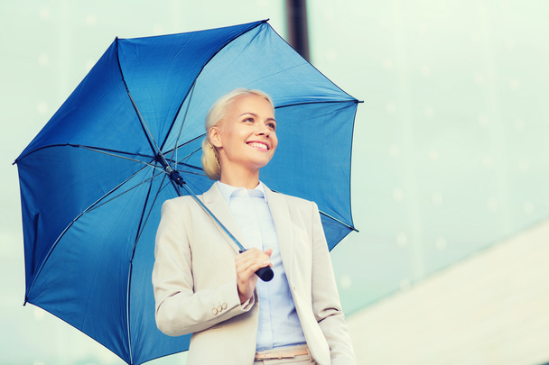 молодая улыбающаяся деловая женщина с зонтиком на открытом воздухе
 - Фото, изображение