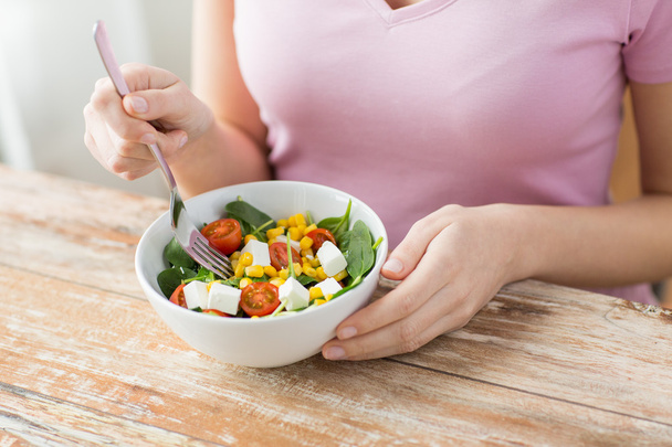 close up of young woman eating salad at home - Foto, Imagen