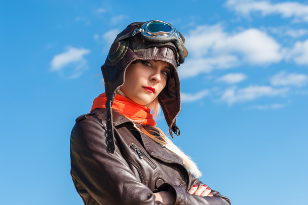 beautiful woman in aviator helmet on the sky background - Photo, Image