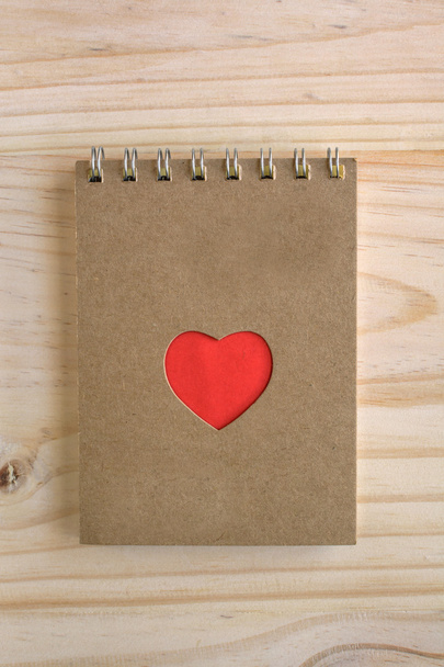 Recycle notebook with red heart shape on wooden desk - Foto, Imagen