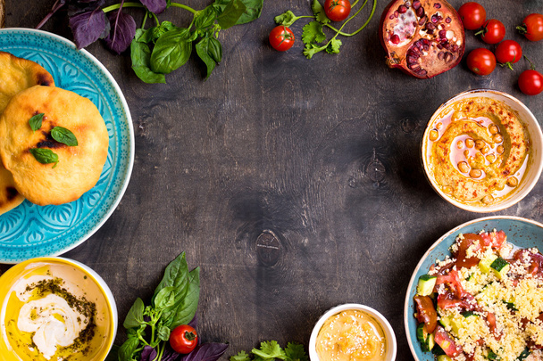 Стол с блюдами ближневосточной вегетарианской кухни. Хумус, тахи
 - Фото, изображение