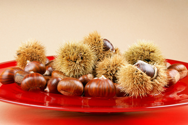 Sweet chestnuts on a red plate - Photo, Image