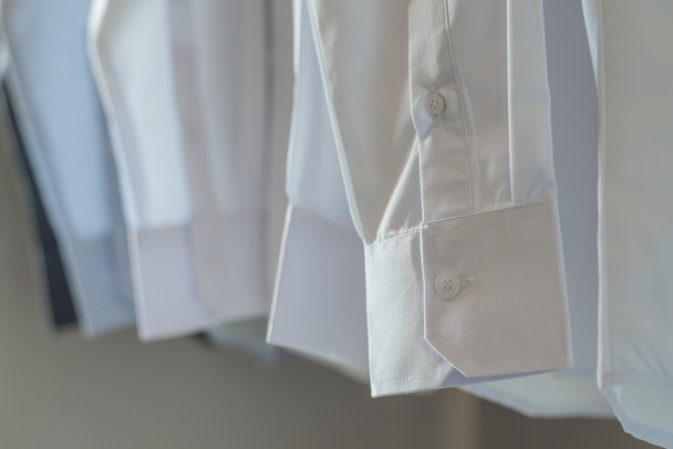 белые рубашки висят на вешалке
  - Фото, изображение