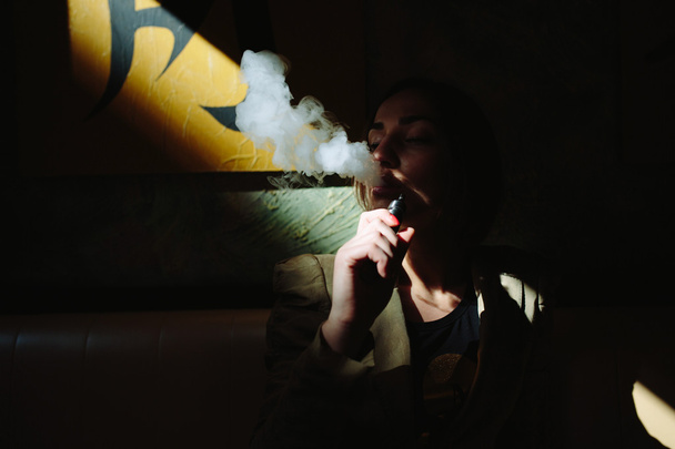 fille s'assoit et fume cigarette électronique
 - Photo, image