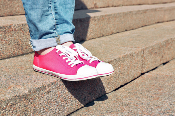 Female feet in pink gumshoes on stone stairs - Zdjęcie, obraz