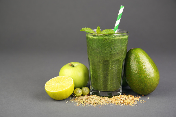Green healthy juice with fruits and spices on gray background - Foto, Bild