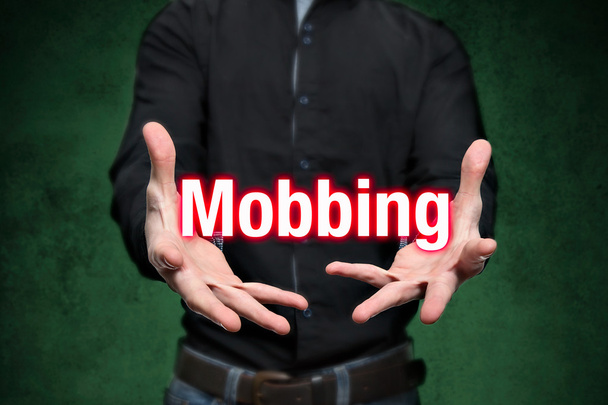 Mobbing, kiusaaminen, mies pitää kirjaimet käsissä
 - Valokuva, kuva