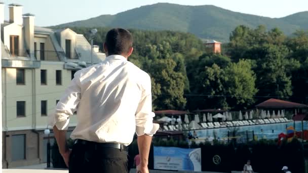 Geschäftsmann spricht auf einem Balkon schönen Hintergrund - Filmmaterial, Video