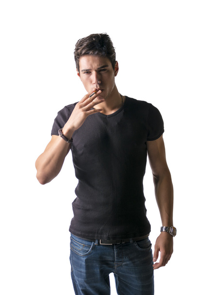 Handsome young man looking at his cigarette - Photo, Image