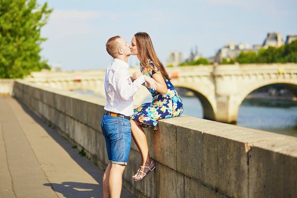 Young romantic couple having on the Seine embankment - Foto, imagen