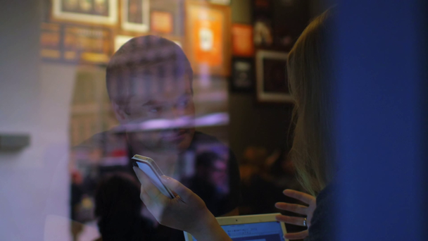 Nő és férfi beszélni az étteremben használ smartphone - Felvétel, videó
