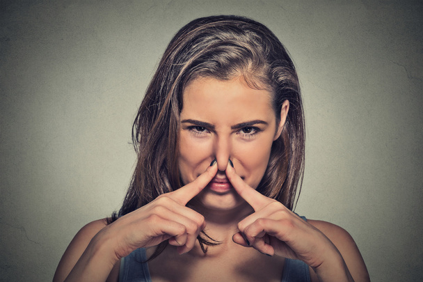 woman pinches nose with fingers looks with disgust something stinks - Foto, Imagen