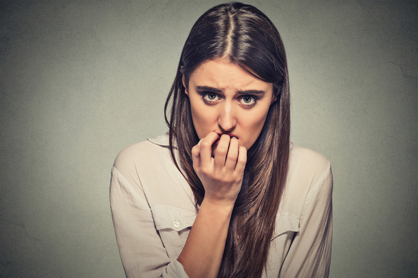 young anxious unsure hesitant nervous woman biting her fingernails - Photo, Image