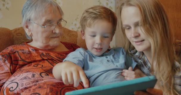 Rodina používá tabletu sedí na pohovce - Záběry, video