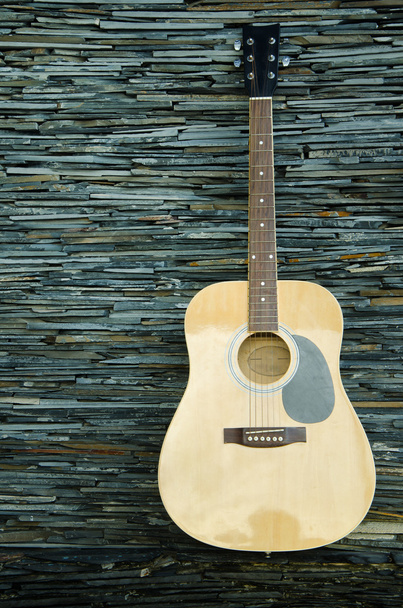 Деревянная гитара против стены
 - Фото, изображение