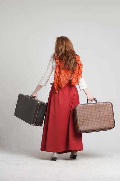 Woman in vintage red skirt with suitcases - Fotoğraf, Görsel