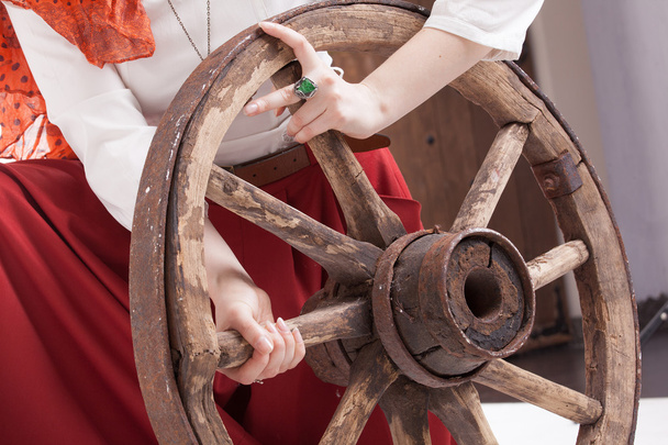 Old wooden wheel an womans hands with a ring - Φωτογραφία, εικόνα