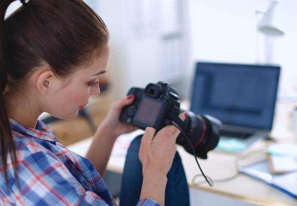 Female photographer sitting on the desk with laptop - Foto, Bild