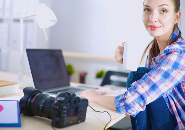 Female photographer sitting on the desk with laptop - Foto, Imagem