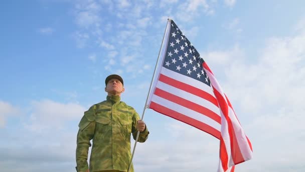 Soldatensalut mit amerikanischer Flagge vor blauem Himmel. Zeitlupenszene - Filmmaterial, Video