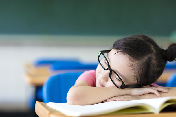 kislány alszik az osztályteremben szemüveg viselése - Fotó, kép