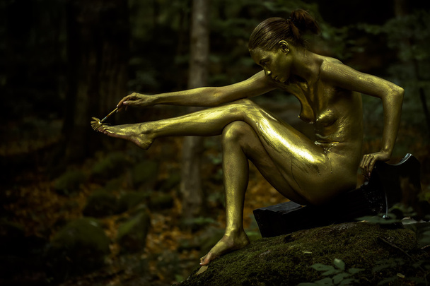 Naked woman painting gold with brush - Foto, immagini