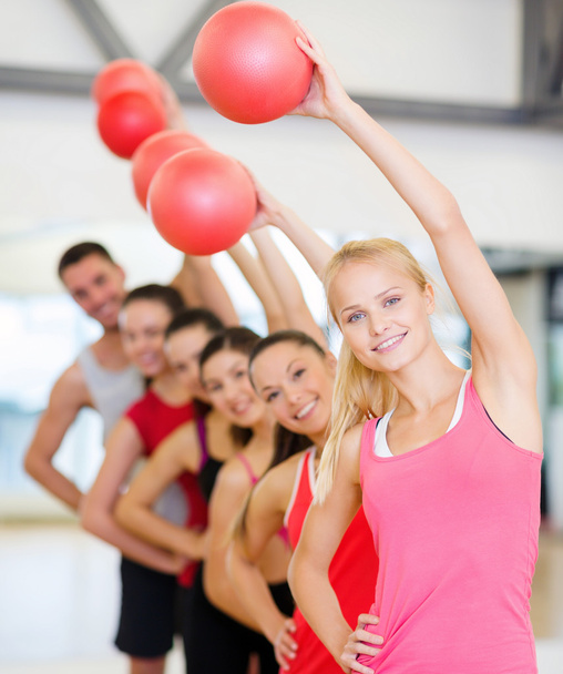 Grupo de personas sonrientes haciendo ejercicio con la pelota
 - Foto, imagen