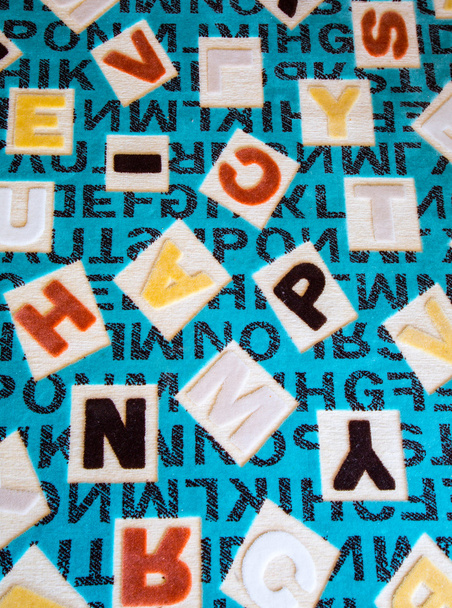 Alfabetos em uma superfície de tapete de tecido
 - Foto, Imagem