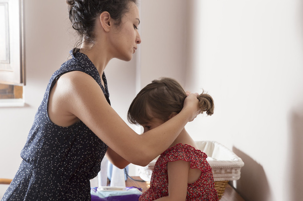 Mutter kämmt die Haare ihrer Tochter - Foto, Bild