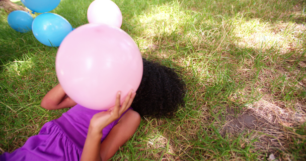 Léggömbök, a füvön játszó afro lány - Felvétel, videó