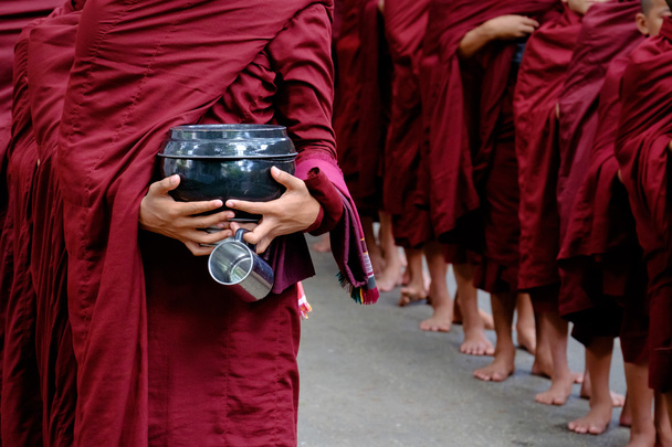 Dettaglio della folla di monaci buddisti e della persona che tiene una ciotola e una tazza
 - Foto, immagini
