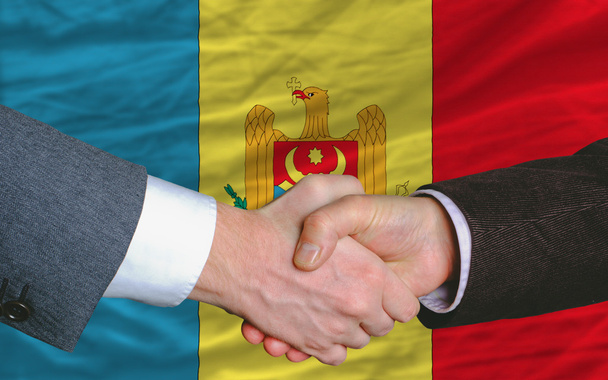 Gli uomini d'affari si stringono la mano dopo un buon affare davanti alla bandiera moldova
 - Foto, immagini
