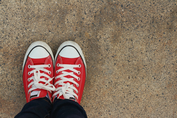 Çimento zemin üzerine kırmızı ayakkabılar. - Fotoğraf, Görsel