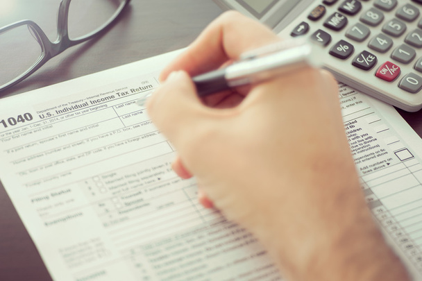 Man invullen van individuele aangifte inkomstenbelasting formulier - Foto, afbeelding