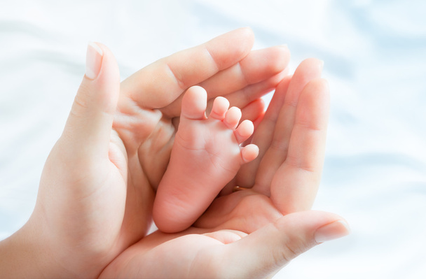 Pie de bebé en manos de madre - Foto, imagen