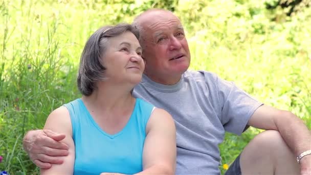 pareja de ancianos sentados en la hierba juntos relajarse - Metraje, vídeo