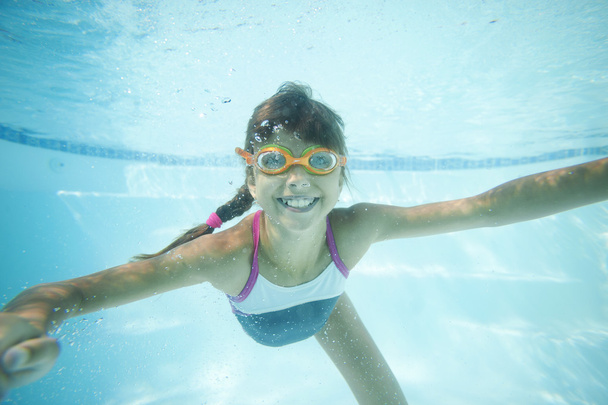 Mädchen schwimmt unter Wasser im Pool - Foto, Bild